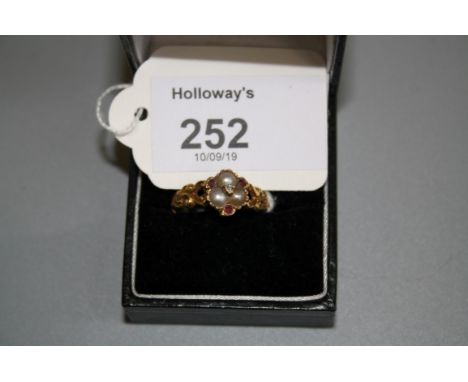 A Victorian gold ring set with seed pearls, rubies and single diamond in a cluster mount, the shank with pierced shoulders, u