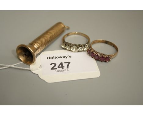 A 9ct gold cigar piercer, engine-turned with suspensory loop, a five stone half hoop ruby ring and a five stone paste ring in