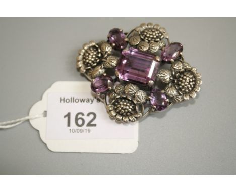 An Arts and Crafts silver and amethyst brooch, attributed to Bernard Instone, the lozenge shaped brooch set with a central st