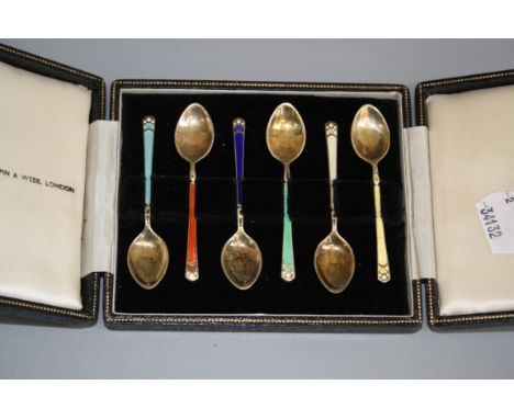 A cased set of six silver gilt and enamel demi-tasse coffee spoons, retailed by Mappin and Webb