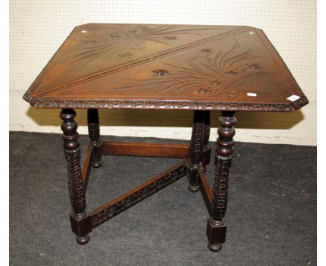 A Victorian oak credence table, the triangular top and single flap carved with flowering baskets on a single gate support wit