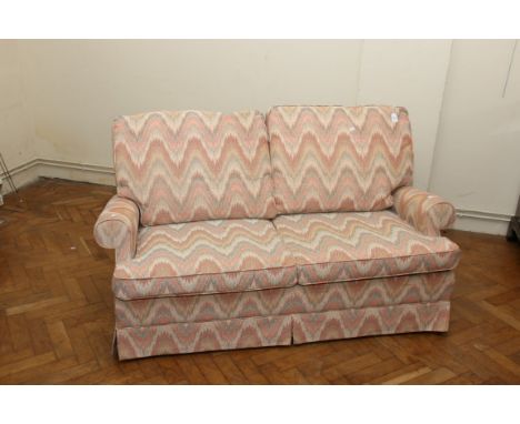 A Parker Knoll two seat metal foldout sofa bed with peach patterned fabric cover