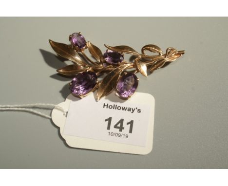 A 9ct gold and amethyst spray brooch, in the style of Bernard Instone, the naturalist spray set with four oval cut amethysts,