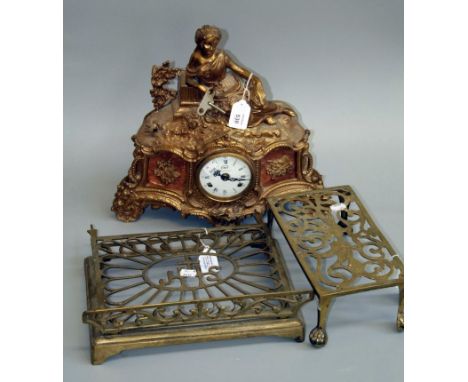 A Victorian pierced brass ratcheting bible stand, together with a brass four leg trivet and a figural mounted gilt mantel clo