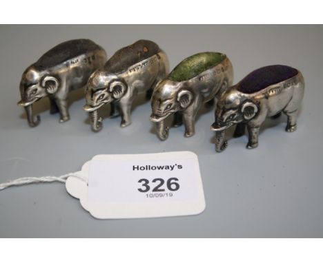 An Edwardian silver novelty pin cushion, in the form of an elephant, Birmingham 1907, together with three similar items (4)
