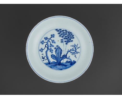 A BLUE AND WHITE ‘THREE FRIENDS OF WINTER’ DISH, KANGXIChina, 1662-1722. The shallow sides rising from a tall ring foot to a 