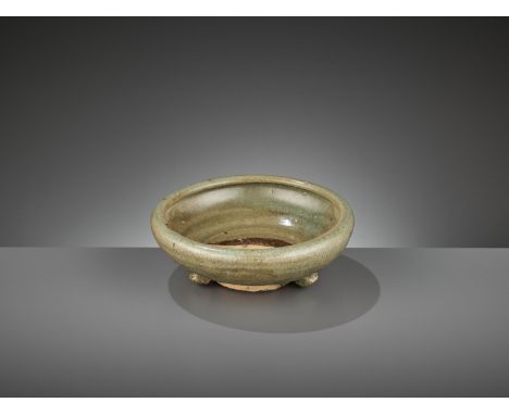 A SMALL LONGQUAN CELADON TRIPOD CENSER, MING DYNASTYChina, 1368-1644. Potted with rounded sides raised on a tall ring foot su