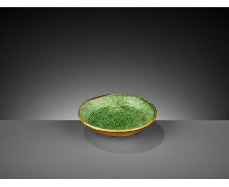 A MOLDED GREEN AND AMBER-GLAZED POTTERY DISH, LIAO DYNASTYChina, 907-1125. The rounded shallow sides rising from a short ring