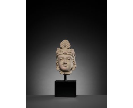 A TERRACOTTA HEAD OF MAITREYAAncient region of Gandhara, 4th-5th century. The head modeled with finely curled hair and wearin