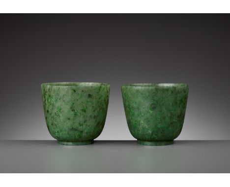 A PAIR OF SPINACH-GREEN JADE CUPS, QING DYNASTYChina, 18th century. Each with deep sides rising from a thick ring foot. The t