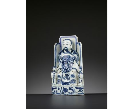 A BLUE AND WHITE PORCELAIN FIGURE OF GUANDI, WANLI PERIODChina, 1573-1620. The God of War seated on a throne, flanked by two 