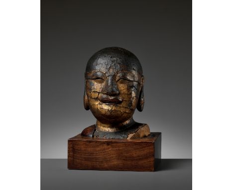 A GILT-LACQUERED WOOD HEAD OF BUDAI, MINGChina, 1368-1644. Covered with a striking gilt-lacquer coating, the Laughing Buddha 