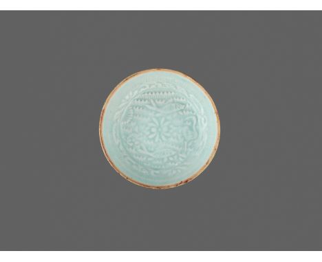 A MOLDED QINGBAI ‘LOTUS POND’ DISH, SOUTHERN SONG DYNASTYChina, 1127-1279. The shallow dish is potted with low, flared sides,