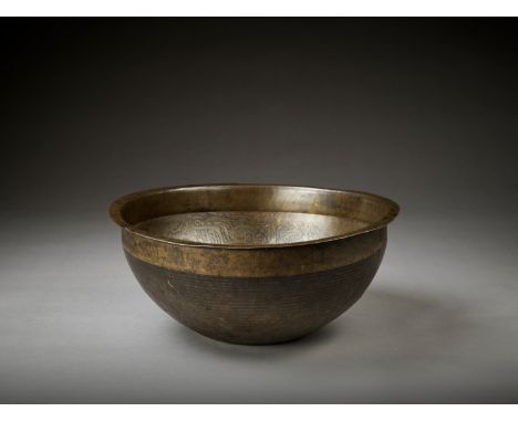 A LARGE INSCRIBED MAMLUK BRASS BASIN, 14TH – 16TH CENTURYSyria or Egypt. Of deep rounded form with a slightly raised central 
