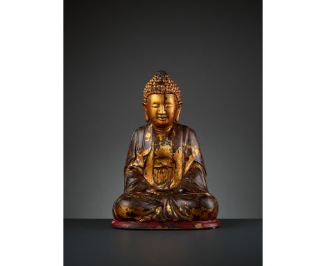 A MASSIVE GILT-LACQUERED WOOD FIGURE OF BUDDHA, 17TH-18TH CENTURYVietnam. Seated in dhyanasana on a red lacquered plinth, the