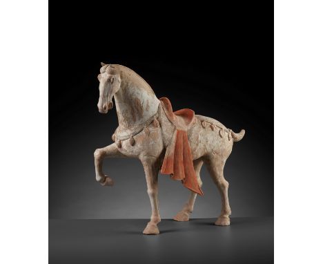 A LARGE PAINTED POTTERY FIGURE OF A PRANCING HORSE, TANG DYNASTYChina, 618-907. The spirited horse is shown standing with its