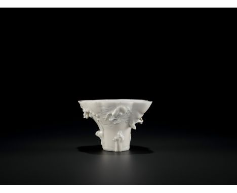 A BLANC-DE-CHINE LIBATION CUP, KANGXI PERIODChina, 1662-1722. Modeled in the form of a rhinoceros horn libation cup, one side