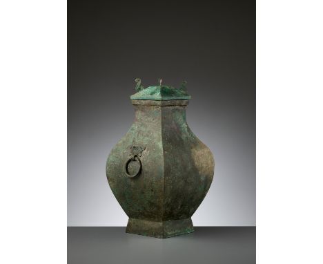 A BRONZE STORAGE VESSEL AND COVER, FANGHU, HAN DYNASTYChina, 206 BC to AD 220. The faceted pear-shaped body, raised on a slig