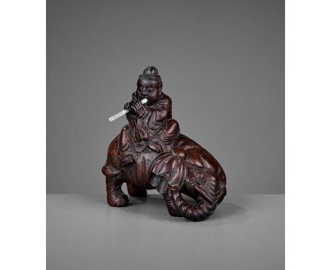 A BAMBOO-ROOT 'ELEPHANT AND BOY' CARVING, EARLY QING DYNASTYChina, 17th – 18th century. Boldly carved as an elephant standing