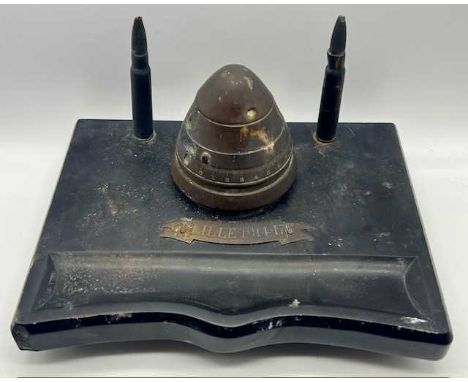 A WWI trench art inkwell, a brass fuse hinged to create the inkwell with decorative bullets on a black marble base with brass