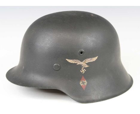 A German M1935 steel helmet with Luftwaffe decal, having a leather liner numbered 57 and leather chin strap, stamped to the s