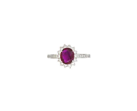 A ruby and diamond cluster ringClaw-set with an oval-cut ruby, measuring approximately 7.9 x 6.5 x 2.8mm, framed by round bri