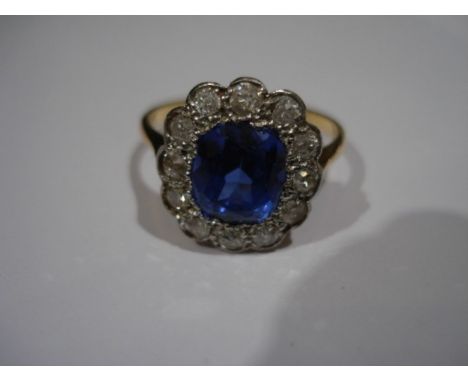 A synthetic sapphire and diamond cluster ringwith central cushion-cut synthetic sapphire, measuring approximately 8.1 x 6.9 x