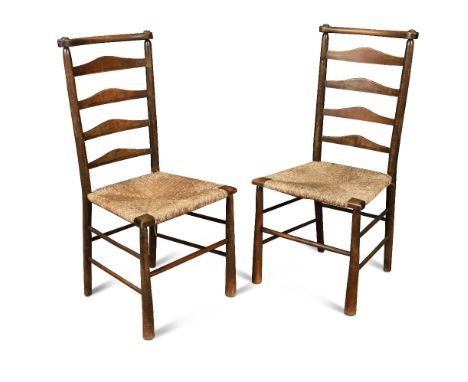 Attributed to C. R. Ashbee for the Guild of Handicraft, a pair of rush seated ladder back chairs, with stained beech frames (