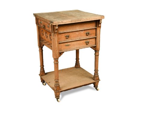 An unusual Gothic oak writing table, the square top with pair of fold-over flaps, a frieze drawer to either side and two furt