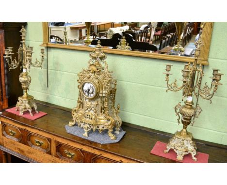 A reproduction gilt metal striking mantel clock with six light candelabra garniture
