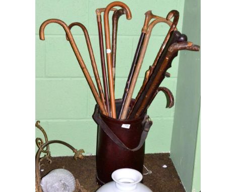 A leather stick stand containing a selection of wood sticks and canes 