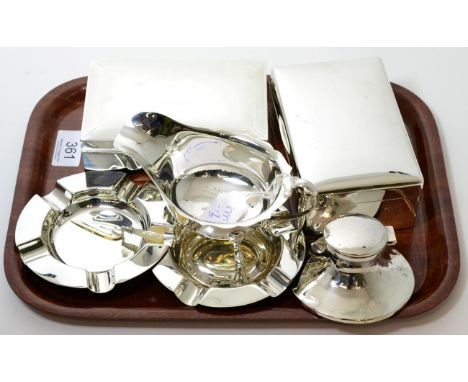 A group of silver comprising two cigarette boxes, a pair of ashtrays a sauce boat, a Capstan inkwell and a mother of pearl tr