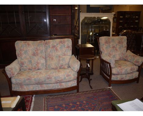 A late 20th Century Ercol three-piece suite, with high back and shaped cresting rails supported by spindles, fitted with loos