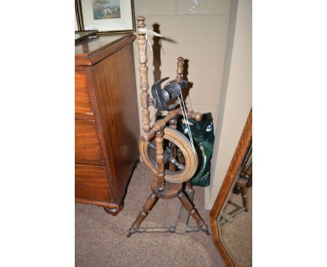 A small stick spinning wheel; together with a polythene bag containing bobbins of lace and lace making equipment.