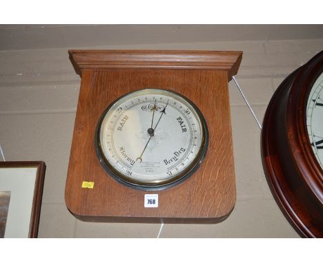 A large circular aneroid barometer, the dial inscribed 'Hughes & Son Ltd.,Fenchurch Street, London', mounted in oak case.