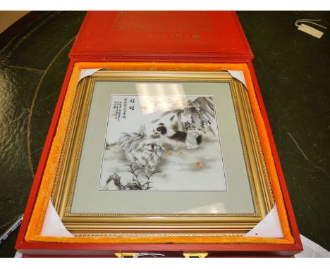 A limited edition Chinese printed ceramic panel depicting two dogs in a landscape, in glazed gilt picture frame; enclosed by 