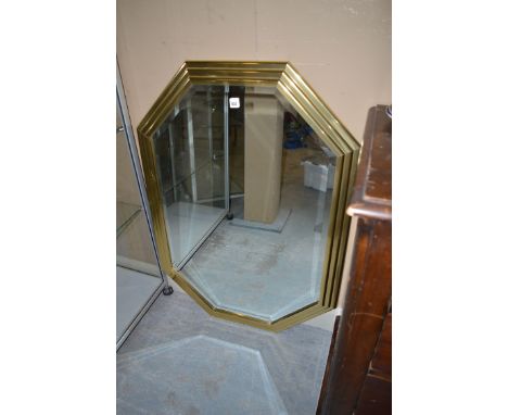 A modern rectangular bevelled mirror with canted corners in a gold coloured step frame. 