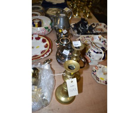 A pair of antique brass candlesticks; a three-piece plated tea service; and a Britannia metal teapot.