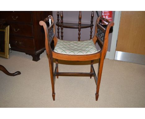 An early 20th Century piano stool, the shaped seat with tapestry upholstery, raised on slender square tapering legs with spad