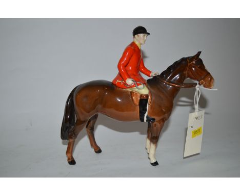 A Beswick ware model of a mounted huntsman in red hunting coat on a brown horse.