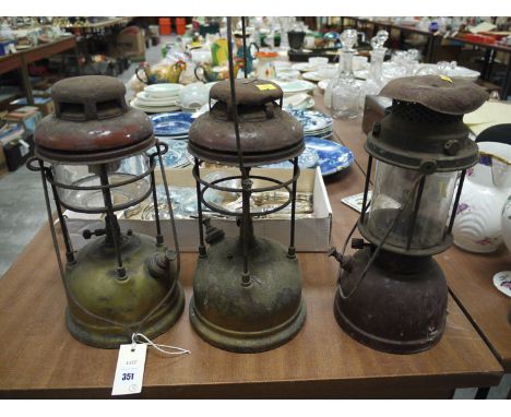 Two Tilley lamps; and another similar lamp.