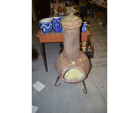 A ceramic chimenea on metal stand.