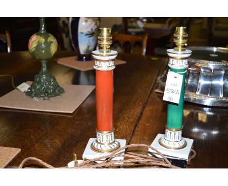 A pair of modern ceramic Corinthian column style table lamps, one in red, white and gold; the other in green, white and gold.