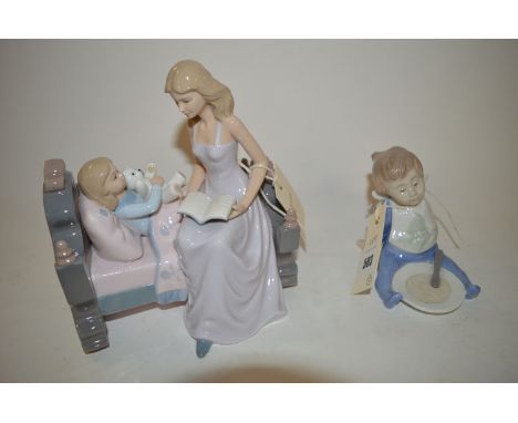 A Nao ornament modelled as a child seated in front of a plate; and another Spanish ware group modelled as a girl reading a bo