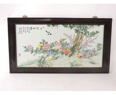 A famille rose ceramic panel, of three cockerels amongst peonies