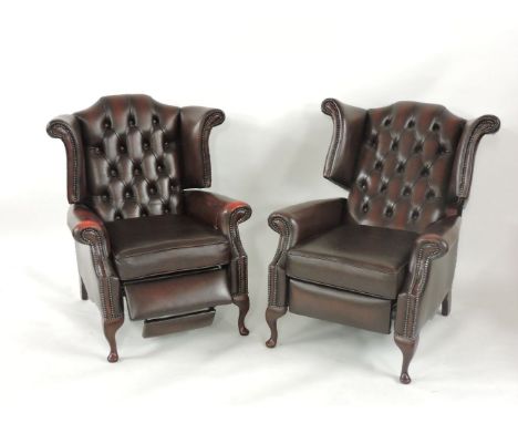 A pair of leather button back reclining armchairs