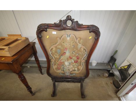 A Victorian carved mahogany wool work firescreen