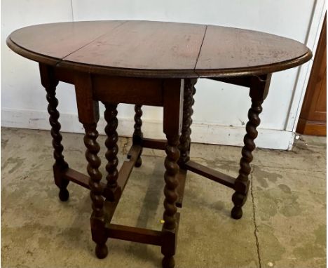 An oak gate leg table on barley twist legs (H72cm W99cm D73cm)