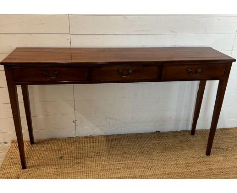 A mahogany three drawer console table with brass drop handles (H77cm W138cm D32cm)