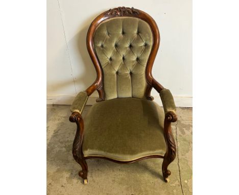A Victorian open arm chair, spoon button back on cabriole legs 